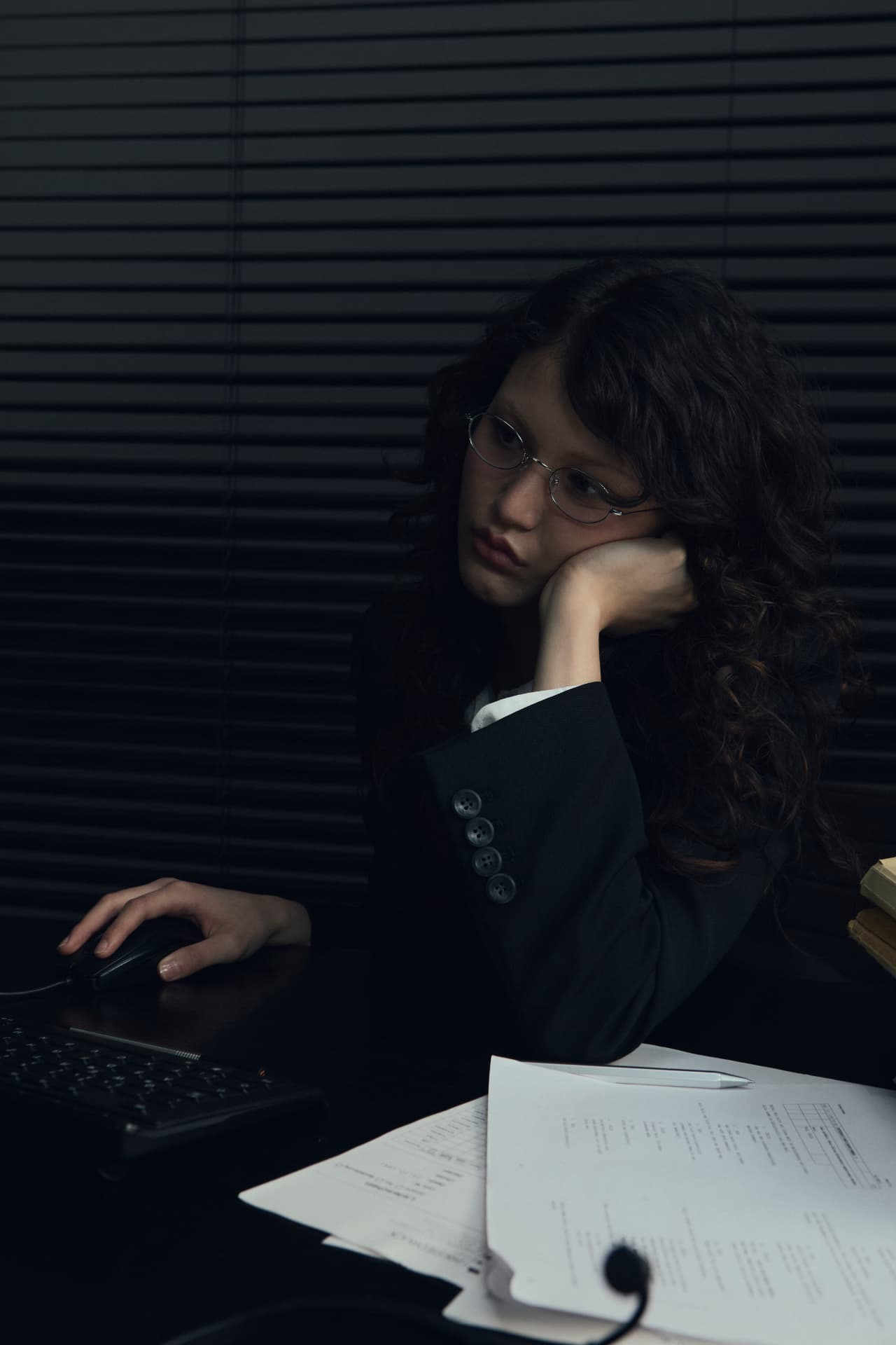 A businesswoman buried in paperwork at her desk
